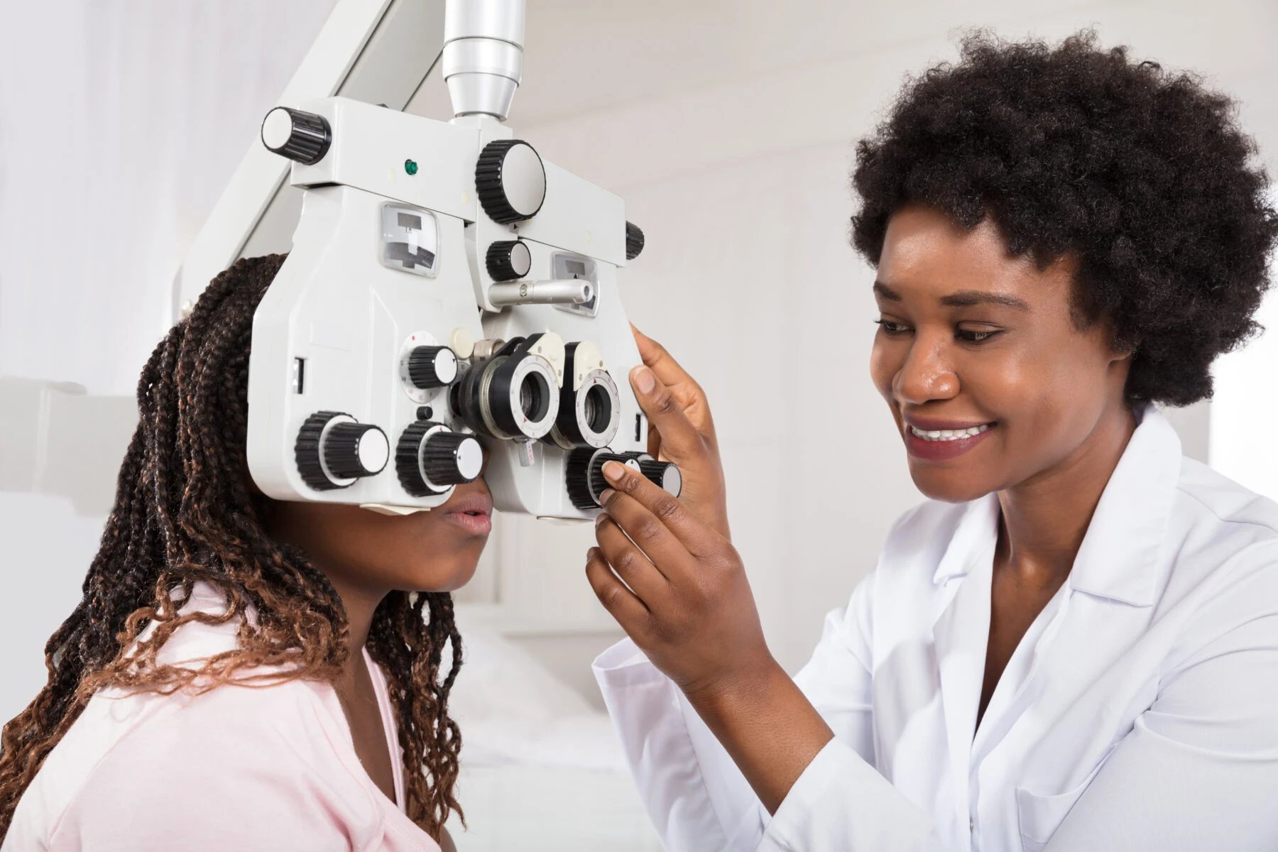 Doctor performing an eye exam with a phoropter at Aqua Vision Care.
